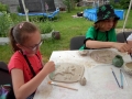 Uczestnicy warsztatów ceramicznych podczas tworzenia rzeźb z gliny.