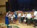 dzieci otrzymują dyplomy i nagrody z okazji ukończenia roku szkolnego