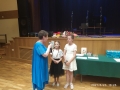 dwie dziewczynki otrzymują dyplomy od nauczycielki