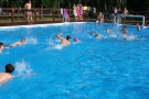 Dzieci i młodzież pływające w basenie