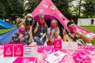 wertepowi wolontariusze na tle różowego festiwalowego namiotu, przed nimi stolik z ulotkami, materiałami promocyjnymi