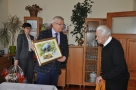 burmistrz wręcza jubilatowi obraz Zbigniewa Budyńskiego