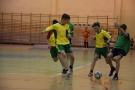 Czetrech chłopców w strojach piłkarskich walczy o piłkę