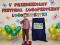Chłopiec stoi przed napisem V Przedszkolny Festiwal Logopedyczny Logowierszyki, w ręku trzyma mikrofon.