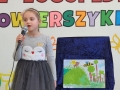 Dziewczynka recytuje wiersz, w ręku trzyma mikrofon.