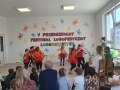 Dzieci prezentują układ taneczny, za nimi napis V Przedszkolny Festiwal Logopedyczny Logowierszyki