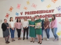 Na zdjęciu widać przedszkolne nauczycielki, za nimi napis V Przedszkolny Festiwal Logopedyczny Logowierszyki.