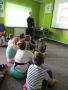 Dzieci oglądają prezentację w sali edukacyjnej  “Ognik” PSP"