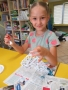 Dziewczynka podczas malowania serca z papierowej wikliny