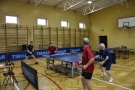 Mężczyźni grają w tenisa stołowego.