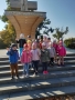 Zdjęcie przedstawia grupę dzieci przy pomniku z napisem: „Bóg jest miłością”.