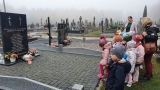grupa dzieci z opiekunkami przy pomniku