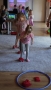 Dzieci podczas zajęć ruchowych na szarym dywanie.