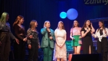 Osiem dziewcząt stoi na scenie.