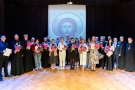 zdjęcie grupowe nagrodzonych festiwalu na scenie Hajnowskiego Domu Kultury, w tle wyświetlona ikona Chrystusa