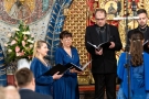 zbliżenie na chórzystów, kobiety w niebieskich sukienkach oraz mężczyzna w czarnym garniturze