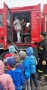 dzieci wsiadają do wozu strażackiego