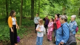 grupa osób stoi w lesie