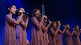 dziewczynki w różowych sukienkach śpiewają na scenie