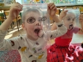 dzieci przykładają do twarzy folie z narysowanymi minami