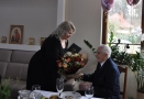 kierownik KRUS wręcza jubilatowi listy gratulacyjne i bukiet kwiatów