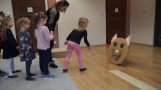 dzieci rzucają piłeczki w kartonowy wizerunek kota