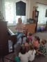 kobieta siedzi przy pianinie. obok siuedzą dzieci 