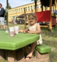 dziewczynka siedząca przy stoliku o zielonym blacie