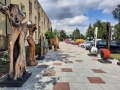 drewniane rzeźby stoją na chodniku przy urzędzie miasta 