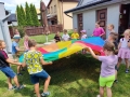 Grupa dzieci podczas zabaw z chustą animacyjną.