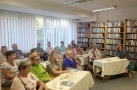 słuchacze na spotkaniu w sali bibliotecznej