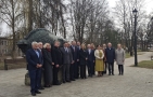 zdjęcie grupowe przedstawicieli delegacji z łotwy, Ambasadora oraz hajnowskich samorządów na tle pomnika żubra