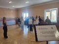 grupa tancerzy na próbie. Na pierwszym planie tablica projektowa