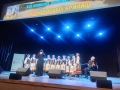 Zespół Pieśni HDK ECHO PUSZCZY na scenie. Nad sceną zwieszony baner z nazwą konkursu.