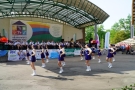 mażoretki tańczą na płycie amfiteatru, orkiestra gra na scenie
