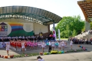 mażoretki tańczą na płycie amfiteatru, orkiestra gra na scenie