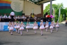 mażoretki tańczą na płycie amfiteatru, orkiestra gra na scenie