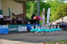 mażoretki tańczą na płycie amfiteatru, orkiestra gra na scenie