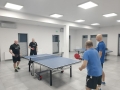 mężczyżni grają w tenisa stołowego