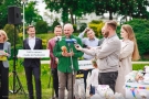 kilka osób na konferencji prezentują plansze z hasłami projetu, mężczyzna przemawia do mikrofonu