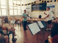 członkowie orkiestry grają na instrumentach podczas próby