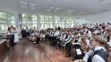 członkowie orkiestry grają na instrumentach. Przed orkiestrą stoi burmistrz i zastępca miasta Hajnówka