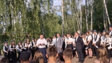Na scenie w parku miejskim stoji Burmistrz Miasta Hajnówka oraz dyrygenci  i orkiestra dęta