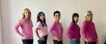 pięć kobiet w różowych bluzkach pozuje do zjęcia