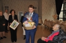 Burmistrz wręcza jubilatce kosz ze słodyczami