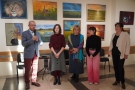 artyści podczas otwarcia wernisażu. W tle widać wystawę ich prac