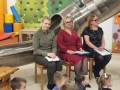 Trzy osoby dorosłe siedzą na krzesłach