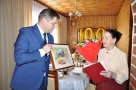 Burmistrz wręcza jubilatce obraz przedstawiający żubra