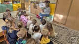 kobieta pokazuje dzieciom książkę