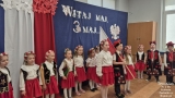  Dzieci w biało-czerwonych strojach prezentują program artystyczny. Stołówka, gdzie odbywała się uroczystość została udekorowana flagami oraz symbolami narodowymi, tworząc wyjątkową atmosferę.